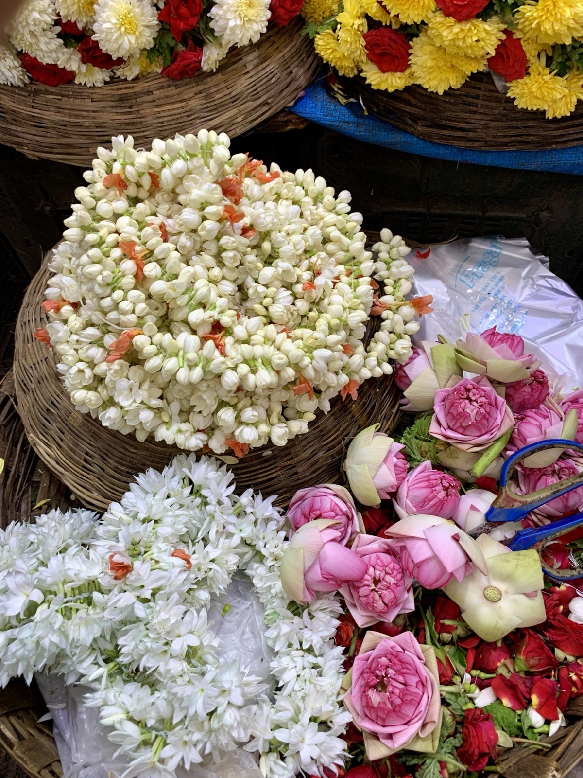 พวงมาลัยมะลิและดอกบัวในตะกร้าที่ตลาดดอกไม้